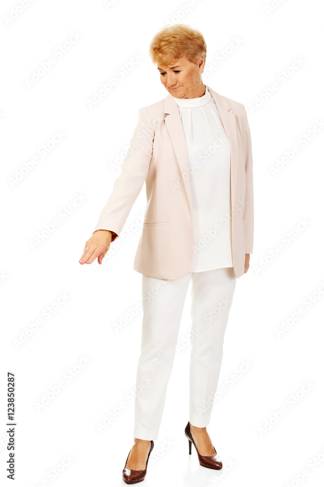 Smile elderly business woman pointing for copyspace or something Smile elderly business woman pointing for copyspace or something