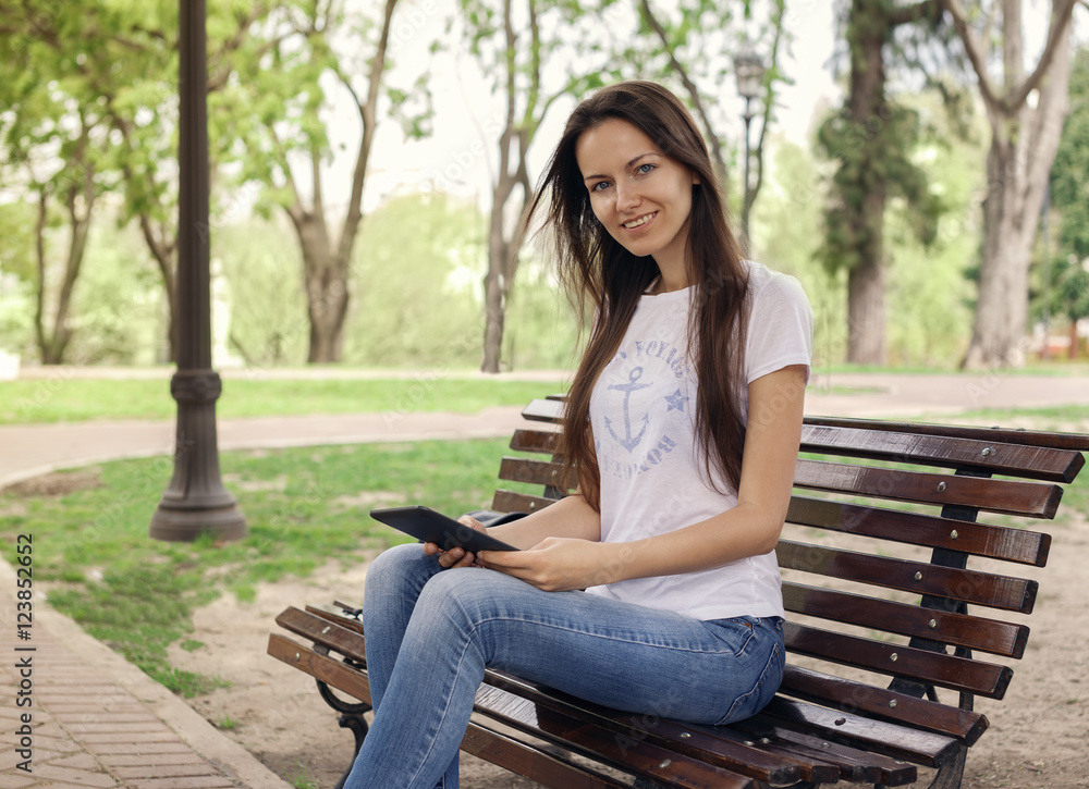Beautiful girl with a e-book in the park Beautiful girl with a e-book in the park