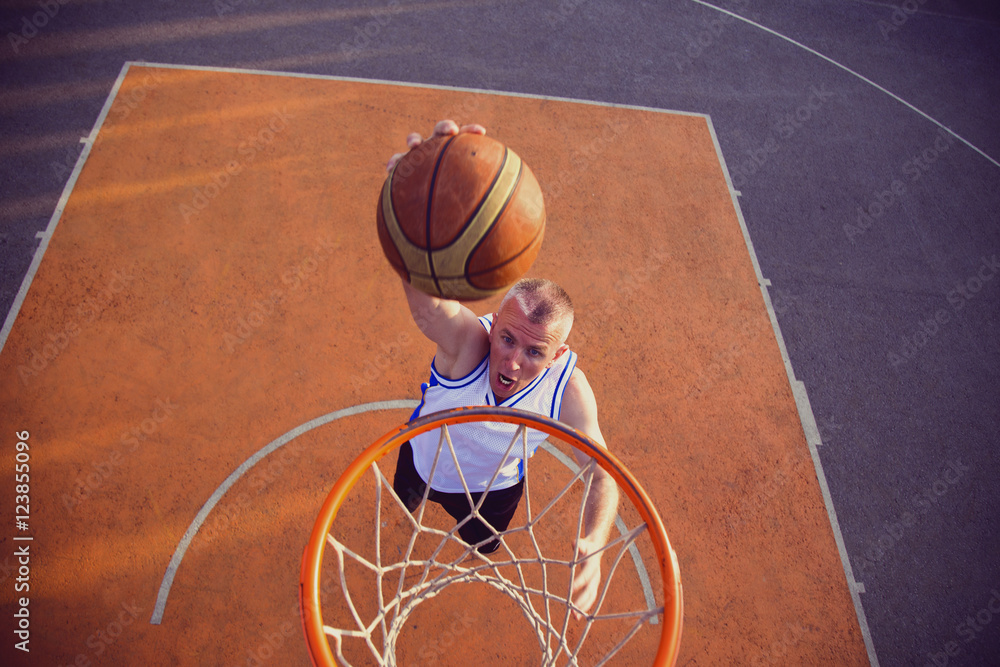 Fototapeta premium Basketball street player making a slam dunk