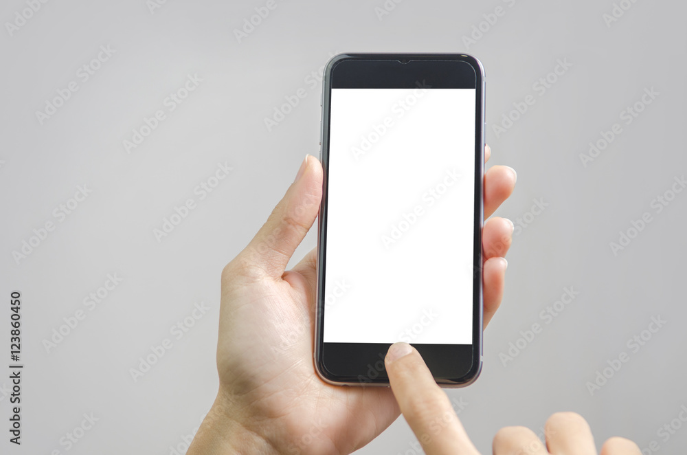 Close up hand holding black phone on white clipping path inside. Gray background.