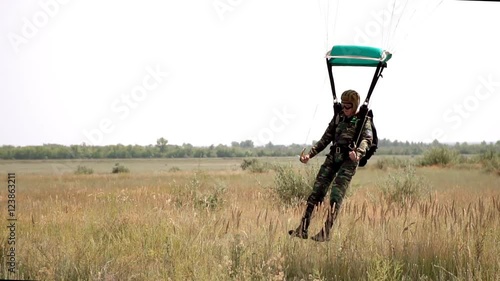 Parachutist hovering in the sky and lands. parachutist landed on the field