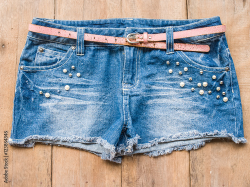 Short jean with belt on wood background
