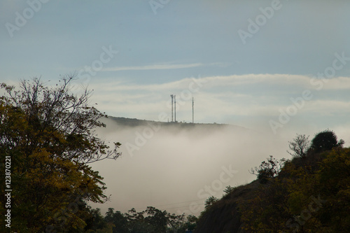 Montaña con niebla / Montaña cubierta de niebla con dos antenas de telefonía en la cima