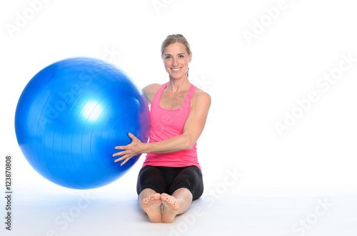 Smiling healthy woman holding a pilates ball