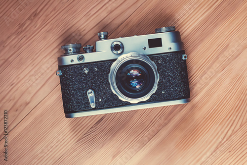 Retro style film camera on a wooden background