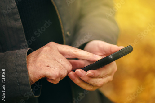 Close up of female hands using mobile phone outdoors