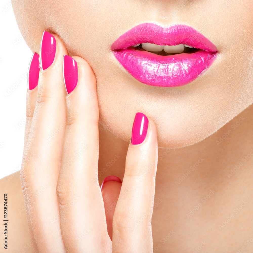 Obraz premium Closeup woman hand with pink nails near lips.