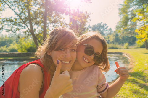 Mother and daughter enjoying in the park. © astrosystem