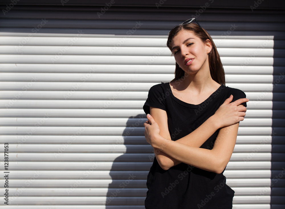 Portrait of girl in rock black style, standing outdoors in the city against the silver metal urban wall Portrait of girl in rock black style, standing outdoors in the city against the silver metal urban wall