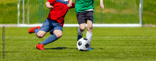 Fototapeta Naklejka Na Ścianę i Meble -  Boys kicking soccer ball. Youth soccer game for kids