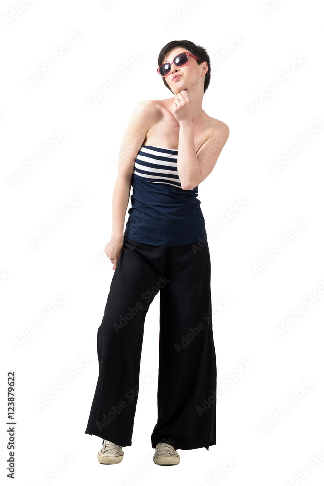 Young flirty short hair trendy beauty with sunglasses blowing a kiss. Full body length portrait isolated over white studio background. Young flirty short hair trendy beauty with sunglasses blowing a kiss. Full body length portrait isolated over white studio background.