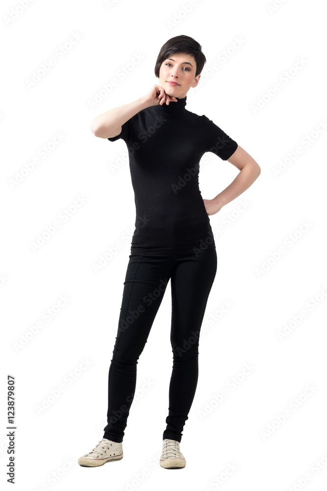 Fototapeta premium Fashionable female model in black turtle neck t-shirt posing with hand on chin. Full body length portrait isolated over white studio background.