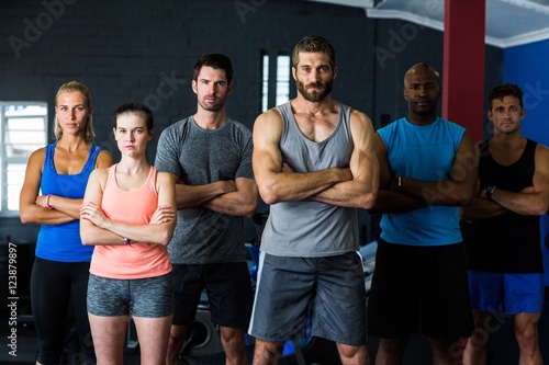 Portrait of serious friends with arms crossed in gym