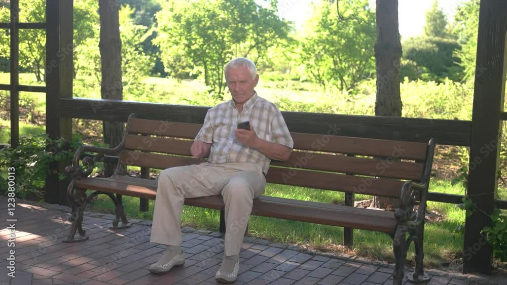 Senior man talks on phone. Elderly male on park bench. Break the silence. Not in mood for talking. Senior man talks on phone. Elderly male on park bench. Break the silence. Not in mood for talking.