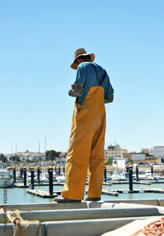 Pescador preparando las redes en el puerto
