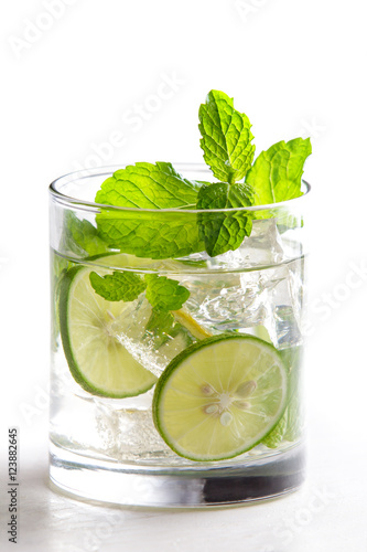 homemade mojito cocktail with fresh limes, mint, and ice