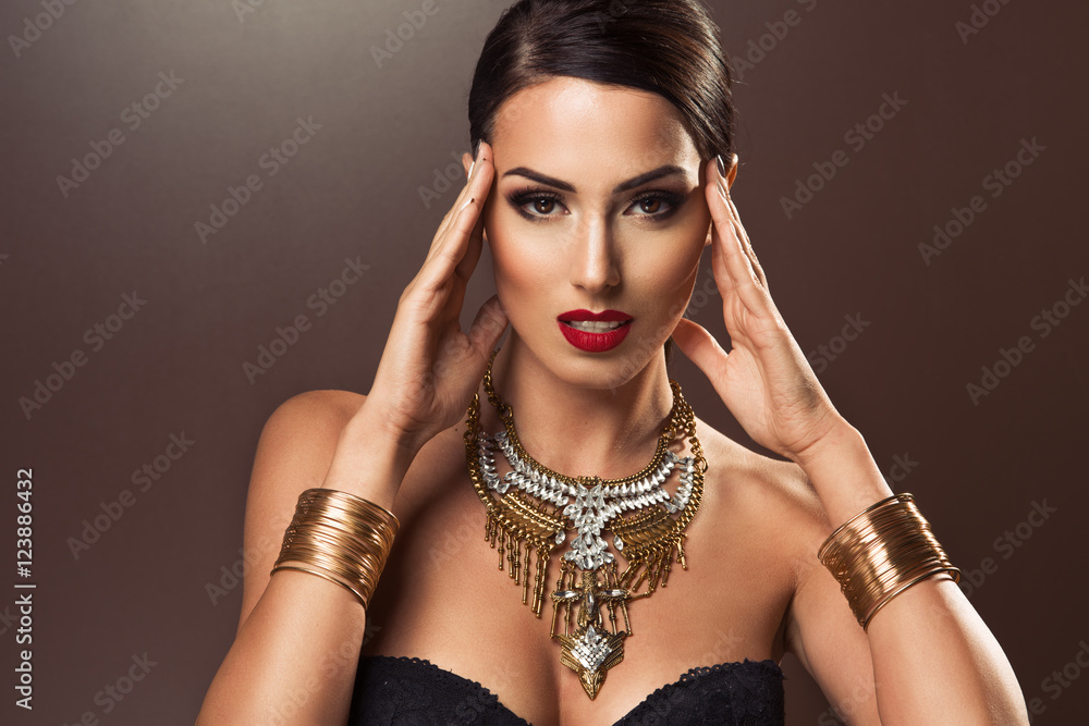 Beautiful woman with gold jewelry looking sexy