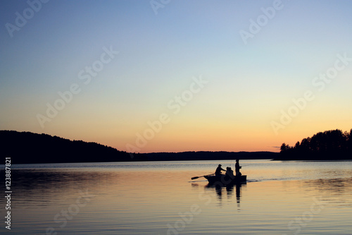 Evening fishing at the lake. Boat with fishermen.