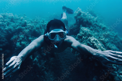 Man snorkeling among seaweed
