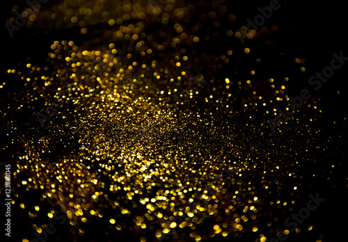 gold glitter lights on black background.
