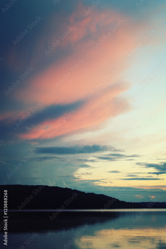 Obraz premium Kenozero lake on an evening. Pink shades of sunset on the clouds. Aged photo. Nature of Russian North. Kenozersky National Park (UNESCO Biosphere Reserve), Russia.