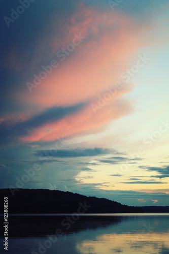 Kenozero lake on an evening. Pink shades of sunset on the clouds. Aged photo. Nature of Russian North. Kenozersky National Park (UNESCO Biosphere Reserve), Russia.