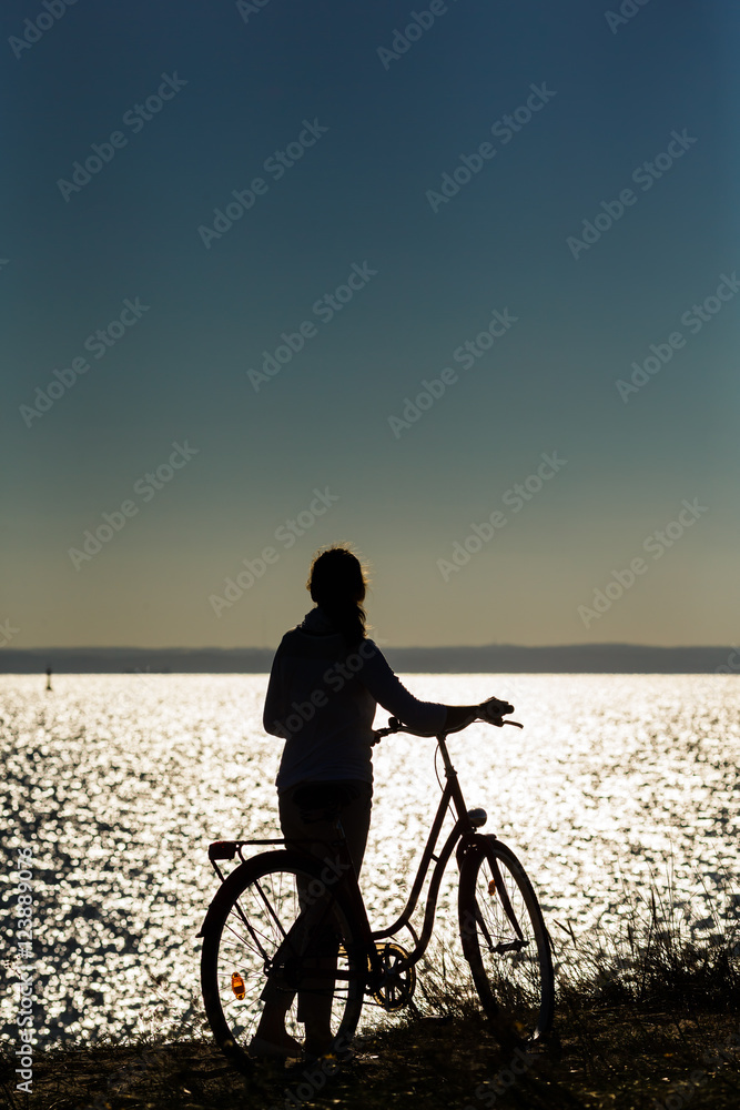 Fototapeta premium Woman riding bike at seaside 