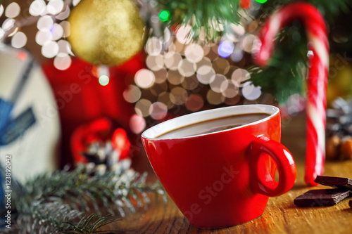 Traditional winter hot chocolate drink near gift boxes under Christmas tree. Delicious cocoa beverage on a table.