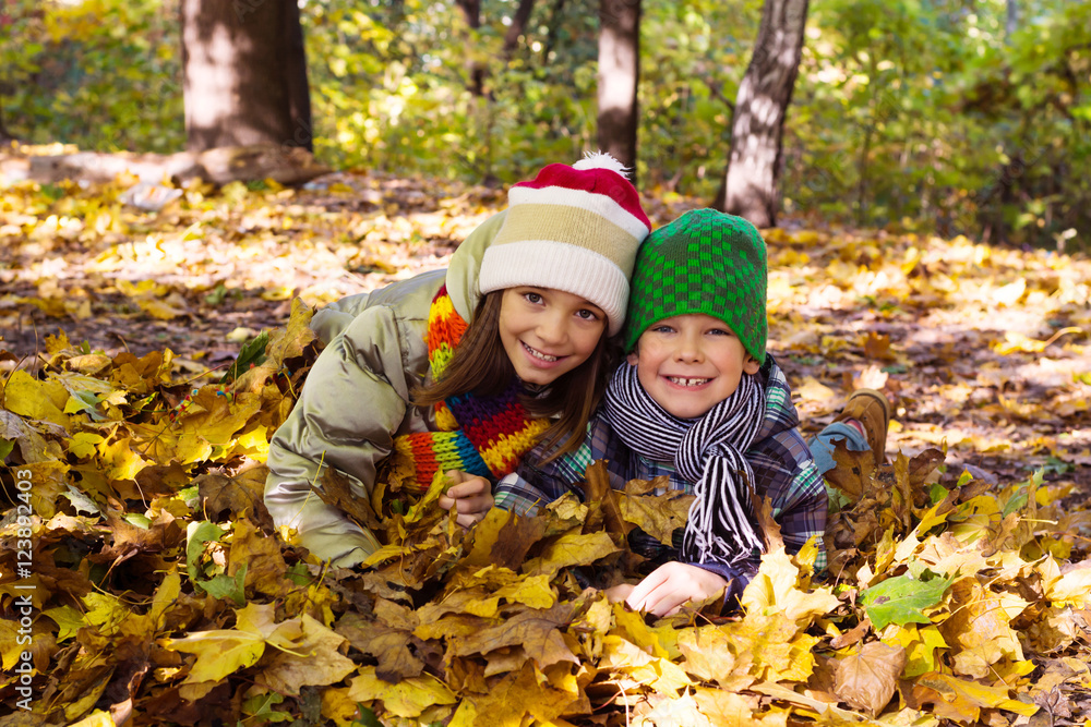 Older sister younger brother playing in autumn leaves, happy Older sister younger brother playing in autumn leaves, happy
