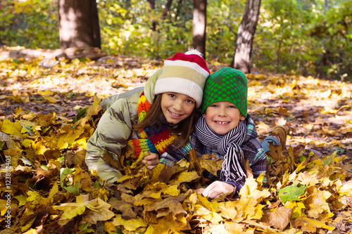 Older sister younger brother playing in autumn leaves  happy