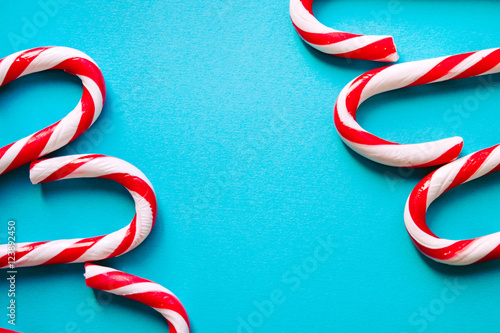 Striped candy canes as walking sticks on the blue surface