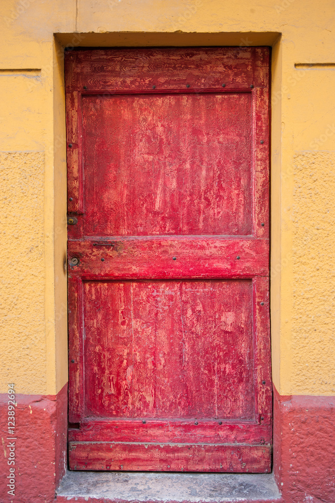 Fototapeta premium Old weathered red door of a building in the mediterranean City of Nice,France