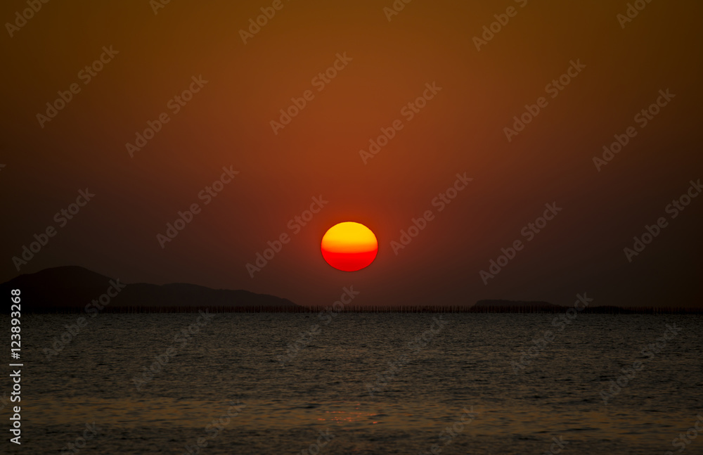 Big red sunset with sea and mountain background