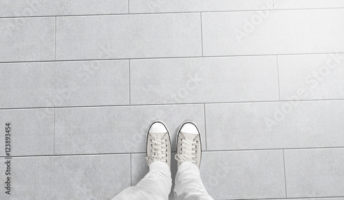 Person taking photo of his foots stand on blank floor, isolated, top view, clipping path. Ground design mock up. Man wear gumshoes and watching down. Deck flooring mockup template.