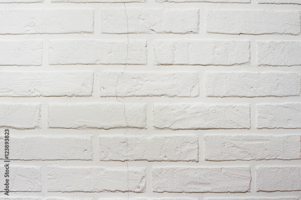 Decorative brick wall with a crack. White hand made wall background Decorative brick wall with a crack. White hand made wall background