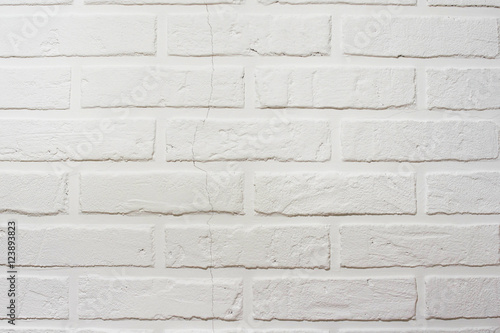 Decorative brick wall with a crack. White hand made wall background