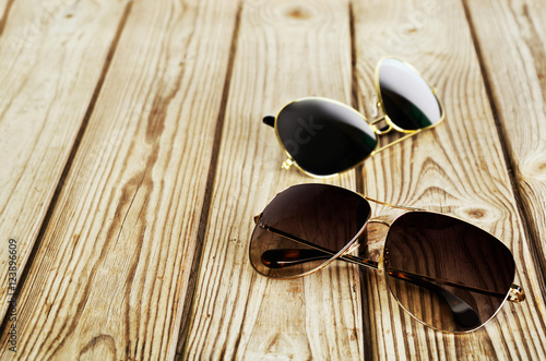 two unisex sunglasses close-up on a wooden background