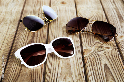 one white woman's sunglasses and two unisex sunglasses close-up