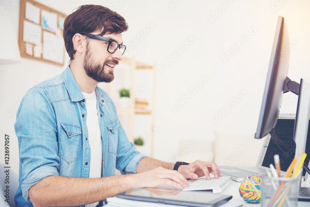 Smiling man programming in an office