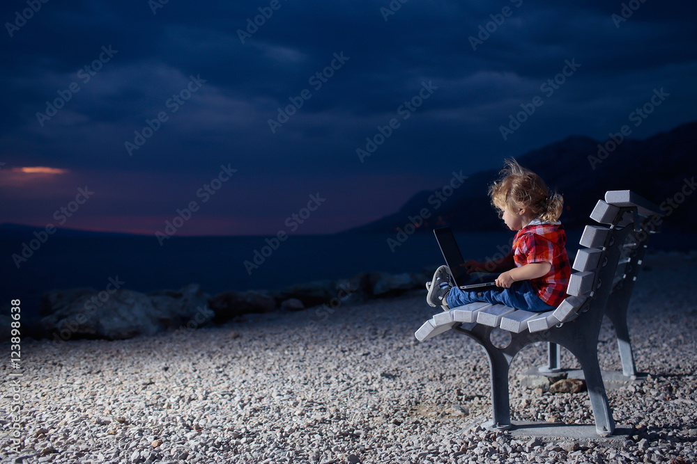 cute boy with laptop on beach