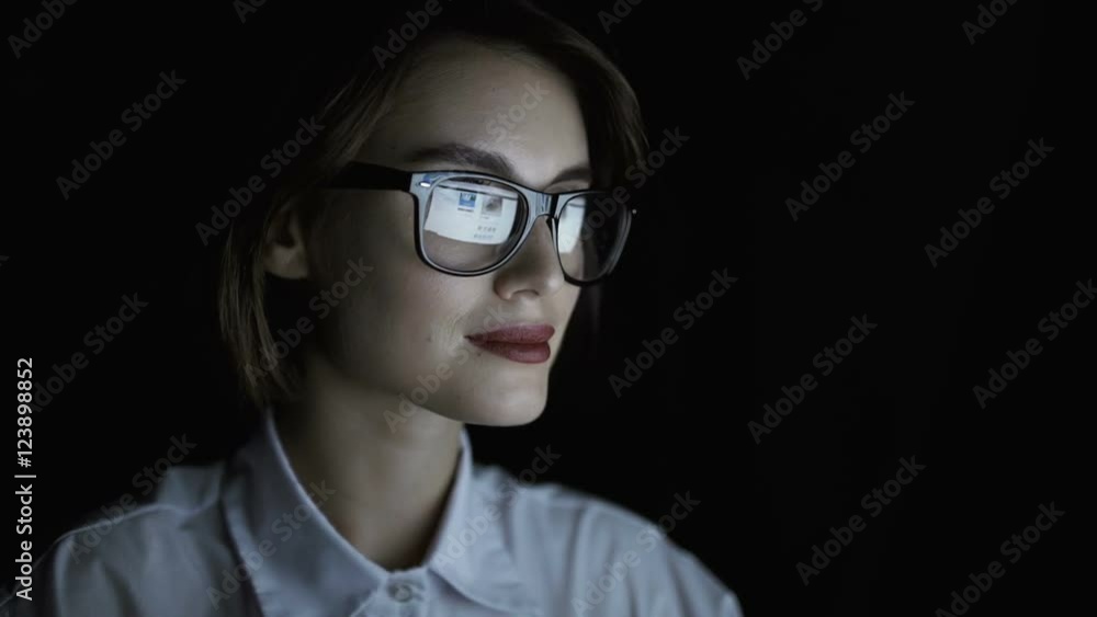 Smiling confident businesswoman in eyeglasses looking at computer screen Smiling confident businesswoman in eyeglasses looking at computer screen