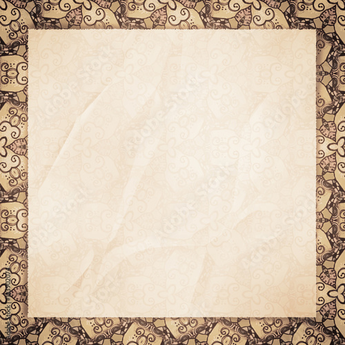 The crumpled form lies on beige wall-paper, with an abstract spi