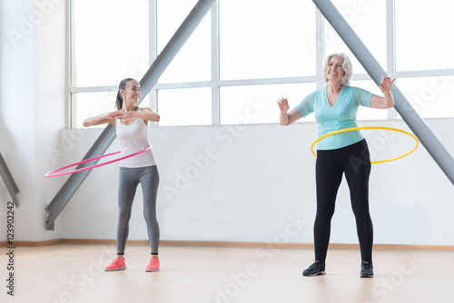 Sporty active women rotating hula hoops
