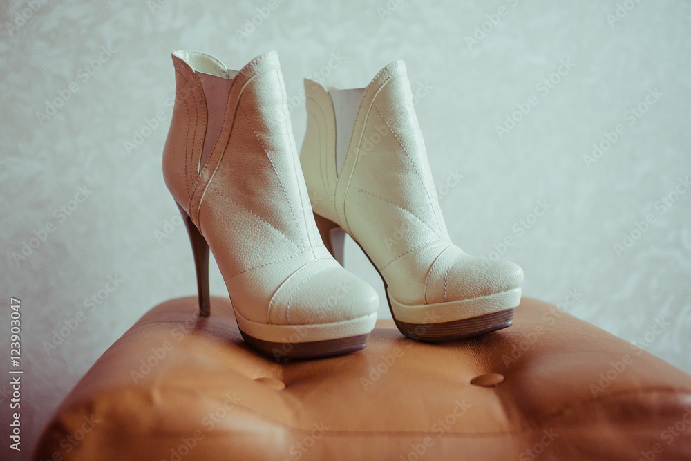 White autumn shoes stand on the leather chair White autumn shoes stand on the leather chair