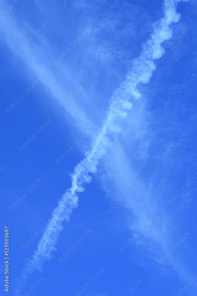 contrail of airplane on blue sky - vertical - portrait
contrail of airplane on blue sky - vertical - portrait