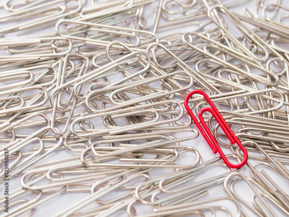 Red paper clip stand different from the crowd on white backgroun Red paper clip stand different from the crowd on white backgroun