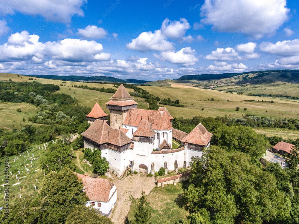 Viscri fortified Chruch in the middle of Transylvania, Romania. Aerial view from drone. Important tourist attraction. UNESCO heritage site.