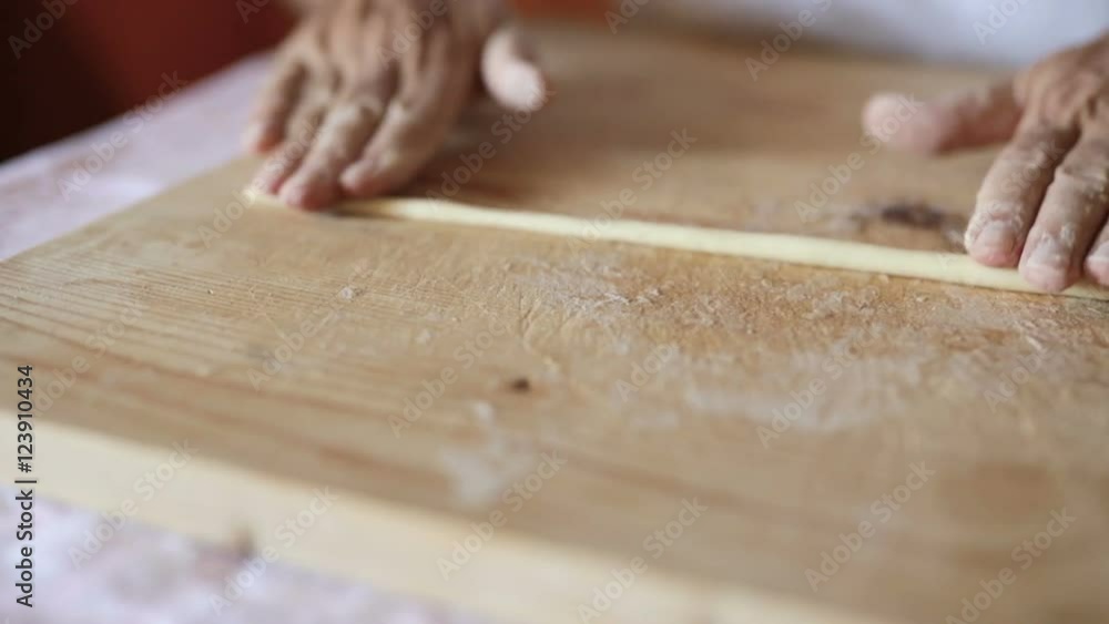 Uomo mezza età che sta facendo la pasta fatta in casa su un tagliere di legno. Uomo mezza età che sta facendo la pasta fatta in casa su un tagliere di legno.