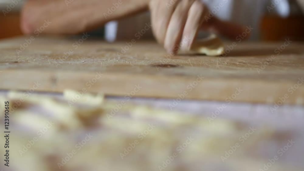 Uomo mezza età che sta facendo la pasta fatta in casa su un tagliere di legno. Uomo mezza età che sta facendo la pasta fatta in casa su un tagliere di legno.