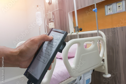 Fotografija the remote control to adjust the level of the hospital bed.